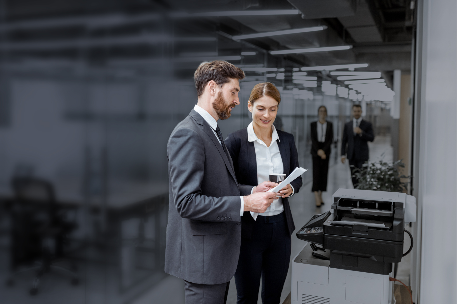 Office employees picking up a printed document from a printer